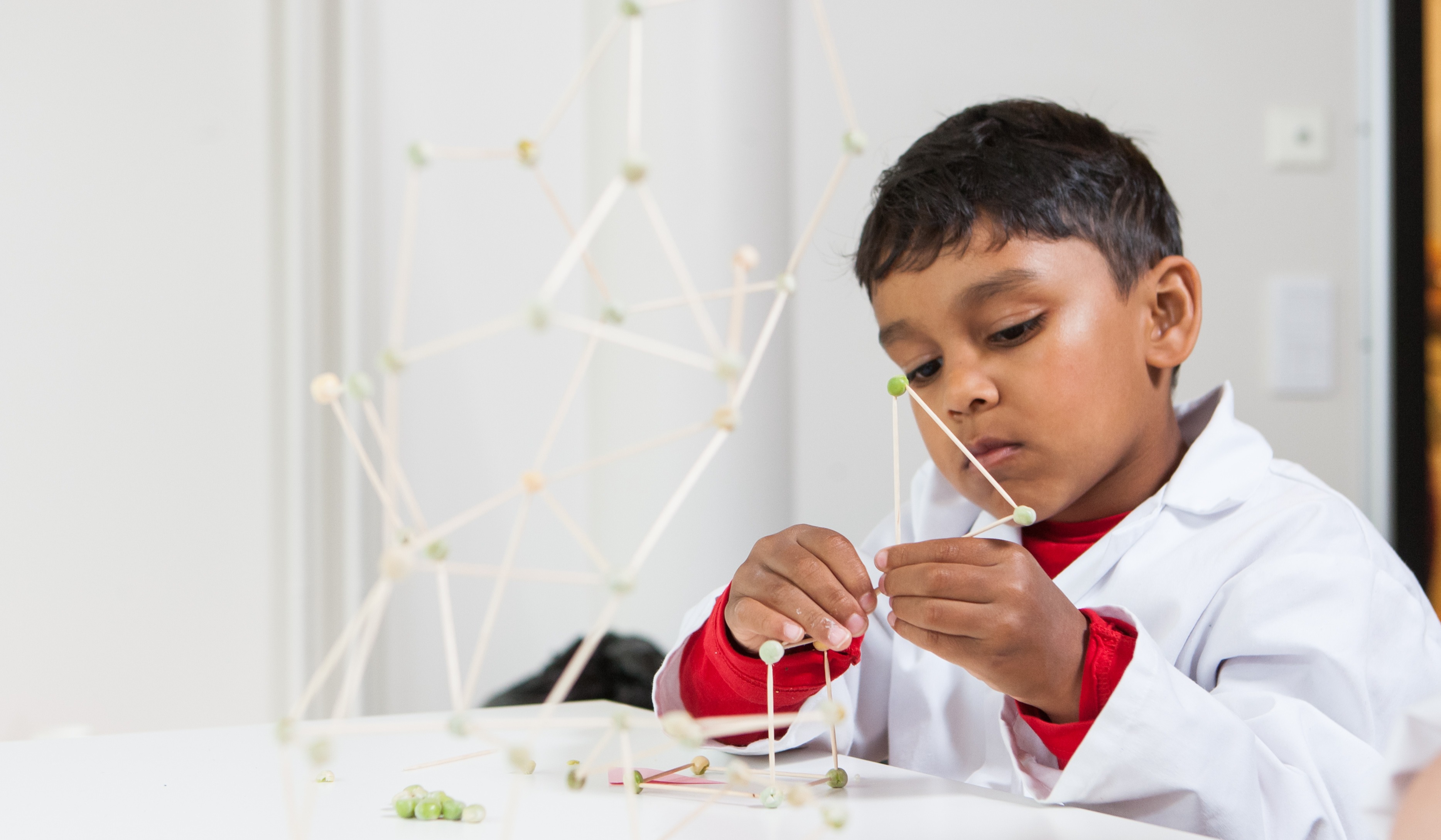 Child building a structure using toothpicks